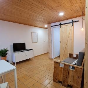 een woonkamer met een televisie en een schuifdeur bij Casas Alba Odeceixe in Odeceixe
