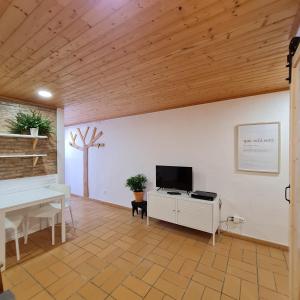 een woonkamer met een tafel en een tv aan de muur bij Casas Alba Odeceixe in Odeceixe