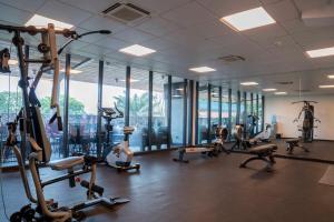 a gym with a lot of exercise equipment and windows at ONOMO Hotel Douala in Douala