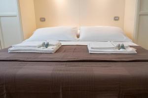 un letto con due asciugamani e due cuscini sopra di Noliday Suite Riviera Luxury Sea Flat a Noli