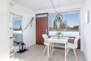 Habitación con mesa blanca, sillas y ventana en Sea-Loft en Timmendorfer Strand