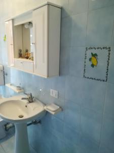 bagno con lavandino e specchio di Sunset Cottage a Cinisi