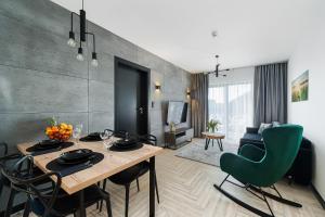 een eetkamer met een tafel en stoelen en een woonkamer bij Apartament Czorsztyn Lake & Ski in Czorsztyn