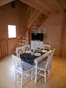 ein Esszimmer mit einem Tisch und Stühlen in einer Hütte in der Unterkunft Kaszubskie Wzgórze - Całoroczne Domki Drewniane in Perlino