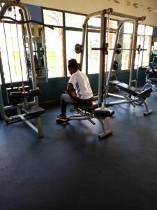a person sitting on a bench in a gym at KING'S CONFERENCE CENTRE in Bujumbura