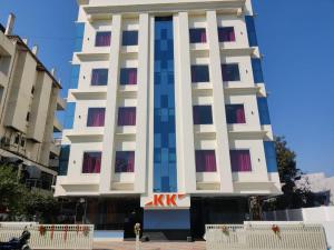 a tall white building with red windows on it at HOTEL AIRPORT KK in Nagpur