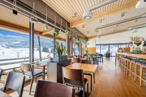 a restaurant with tables and chairs and mountains in the background at Swiss Mountain Golf-Restaurant Gonten in Gonten