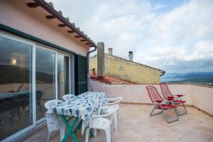 a patio with a table and chairs on a balcony at Casa Natura & Relax-Goelba in Marciana