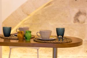 una mesa con tres tazas y jarrones. en S25, en Monopoli