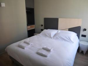 a bedroom with a white bed with two towels on it at Le Chat Qui Dort - Vieux Lille III in Lille