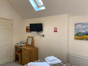 a bedroom with a bed and a television on the wall at The Parson Woodforde in Norwich