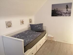 Bett in einem Zimmer mit einem weißen Bettrahmen in der Unterkunft Steinmarner Bude in Cuxhaven