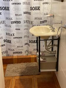 baño con lavabo y pared con escritura en casa Muñiz en 