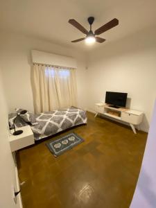 1 dormitorio con 1 cama y ventilador de techo en casa Muñiz en 