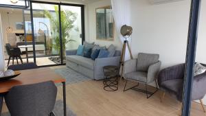 Home at Azores - Oasis House في ساو روكي: غرفة معيشة مع أريكة وكرسيين وطاولة