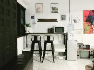 a kitchen with two stools and a table with a computer at Gfeel Hostel in Bangkok