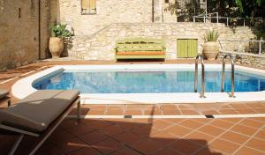 a swimming pool with a bench next to a building at Villa Irini in Vafés