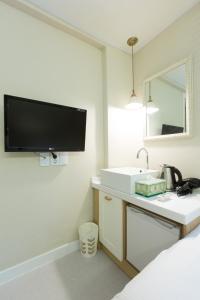 ソウルにあるホテル ガオン ソウル トンデムンのバスルーム(洗面台付)、壁掛けテレビが備わります。