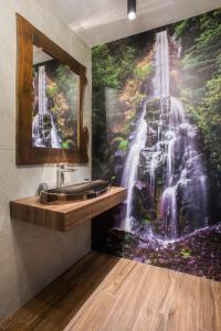 un bagno con un murale a cascata sul muro di Sidharta Resort a Obârşia Lotrului
