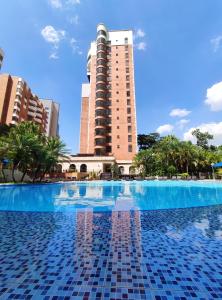 a swimming pool in front of a tall building at Hotel Dann Carlton Medellín in Medellín