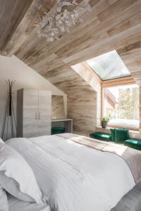 um quarto com uma grande cama branca e uma janela em Sidharta Resort em Obarsia-Lotrului