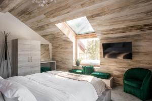 um quarto com uma cama e 2 cadeiras verdes em Sidharta Resort em Obarsia-Lotrului