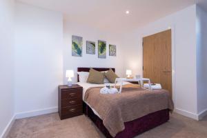 a bedroom with a bed with two lamps on it at SUBLIME STAYS - Derby City Centre Apartments in Derby