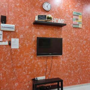 Una pared con TV y reloj. en D'Q Putra Homestay Melaka (Unit AMAR), en Melaka