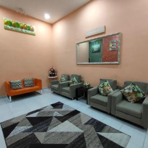 una sala de espera con sofás y espejo en D'Q Putra Homestay Melaka (Unit AMAR), en Melaka
