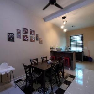 a dining room with a table and chairs and a kitchen at D'Q Putra Homestay Melaka (Unit AMAR) in Melaka