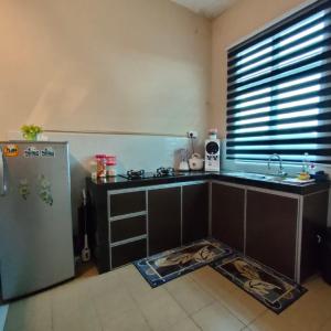 a kitchen with a sink and a refrigerator at D'Q Putra Homestay Melaka (Unit AMAR) in Melaka