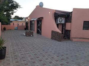 a pink building with a door and a patio at Quiet Getaway in Bloemfontein