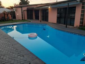 a swimming pool with blue water in front of a house at Quiet Getaway in Bloemfontein