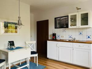 a kitchen with white cabinets and a sink at Kajüthus Apartment 1 in Fehmarn