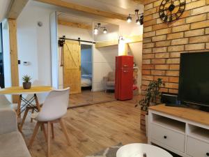 - un salon avec une table et un réfrigérateur rouge dans l'établissement Apartament ALPa Kudowa Zdrój, à Kudowa-Zdrój