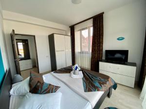 a hotel room with two beds and a television at Apartament Ella T2 in Mamaia Sat/Năvodari