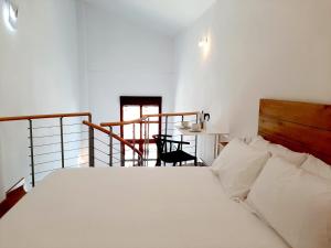 a bedroom with a large white bed and a chair at Apartamentos Candelario by gaiarooms in Candelario