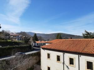 un edificio con techo de baldosas rojas y una calle en Apartamentos Candelario by gaiarooms, en Candelario