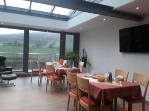 un comedor con mesas y sillas y una gran ventana en Vierburgeneck, en Neckarsteinach