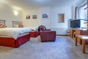 a bedroom with two beds and a flat screen tv at Lann Dearg Studios in Invermoriston +35 photos