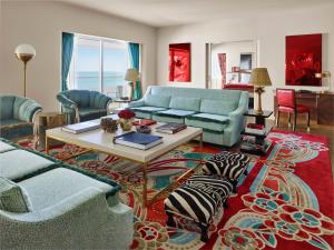 a living room with blue couches and a table at Faena Hotel Miami Beach in Miami Beach