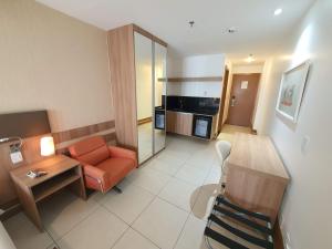 une chambre d'hôtel avec un canapé et une table dans l'établissement Flat no Athos Bulcão Executive By Rei dos Flats, à Brasilia