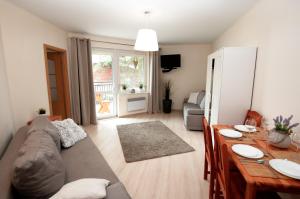 a living room with a couch and a table at Apartament IKAR blisko morza in Pobierowo