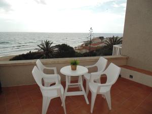 a table and chairs on a balcony with the ocean at Hotel Llorca in Platja de l’Almadrava
