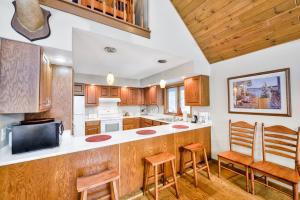 a kitchen with wooden cabinets and a counter with stools at Tall Pines in Swanton