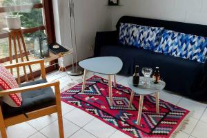 ein Wohnzimmer mit einem blauen Sofa und einem Tisch in der Unterkunft La maison sous les arbres in Gouvy