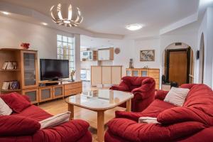 a living room with two red chairs and a table at Apartment Emilija in Skopje