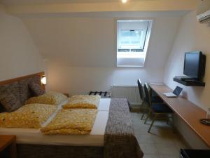 Schlafzimmer mit einem Bett, einem Schreibtisch und einem TV in der Unterkunft City Hotel in Ludwigsburg