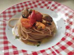 a plate of pasta with mushrooms and tomatoes on a table at Villa Lorenza in Fasano