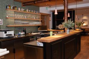 a kitchen with a bar with glasses on the wall at Gasthaus Stöttnerbräu in Vohburg an der Donau